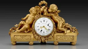 Clock surrounded by gilt-bronze sculptures of flowers, two babies, and doves