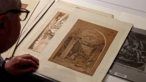 video still of Stephen Bury looking at prints in library