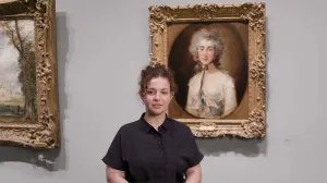 video still of Besmira Rraci standing in front of painting of woman