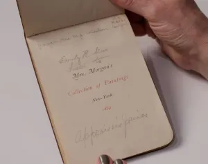 Hands holding a small guidebook with the title 