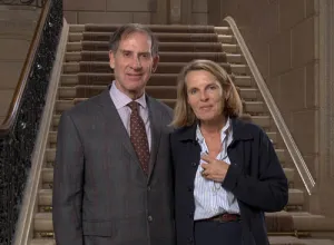 A man and woman standing in front of stairs