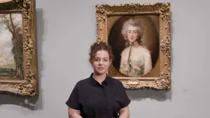 video still of Besmira Rraci standing in front of painting of woman