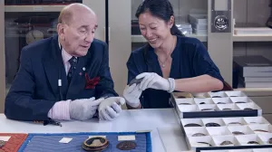 photo of Stephen K. Scher, along with Aimee Ng, handling medals