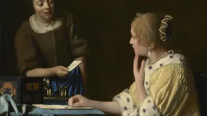 A woman is seated at a table, looking back at another woman handing her a letter.