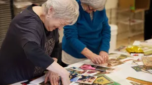 Two older women making collages