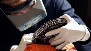 video still of conservator working on object