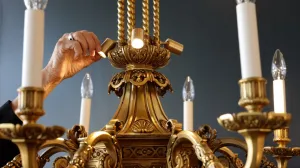 video still of chandelier and hand adjusting fixture