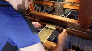 video still of man working with loom