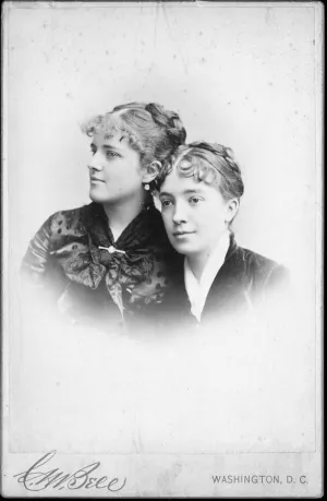 Black-and-white portrait photograph of two young adult sisters, gazing to their left