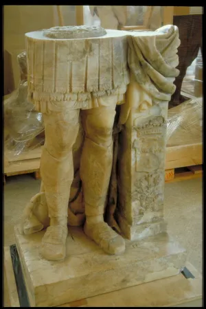 Marble sculpture of legs detached from a larger statue on a pedestal
