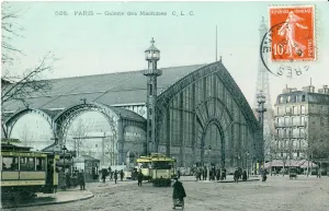 Postcard with a stamp depicting the Galerie des Machines in Paris, a large steel-and-glass pavilion, with the Eiffel Tower in view at right.