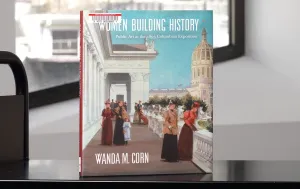 Book with an artwork detail of women on a terrace on its cover on a library cart in front of a window