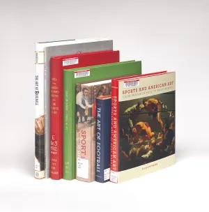 Seven library books about sports in art stacked 