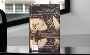 Book with a detail of the Eiffel Tower on its cover on a library cart in front of a window