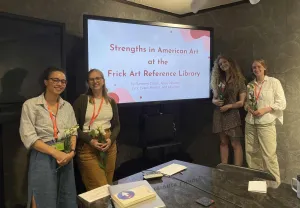Four interns posing around a screen that reads 