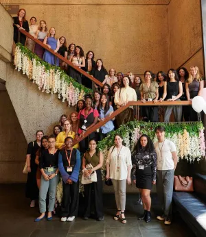 Group of young people lined up on stairs decorated with flowers