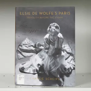 Book cover on a shelf featuring a photo of an elegant woman in a gown seated on the floor