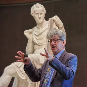 man speaking in front of statue