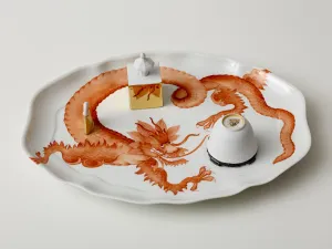 photo of white porcelain dish decorated with large red dragon and cup-like objects