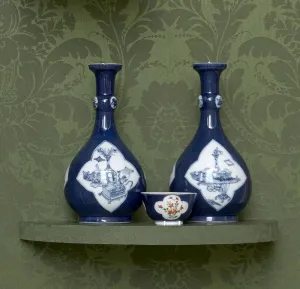 pair of dark blue porcelain vases shaped like bottles with white frame and blue decoration
