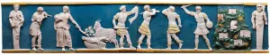 lazed terracotta frieze depicting a number of figures in ancient dress.