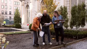 video still of three people in a garden