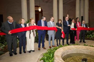ribbon cutting ceremony at the Frick Collection with multiple people holding red ribbon